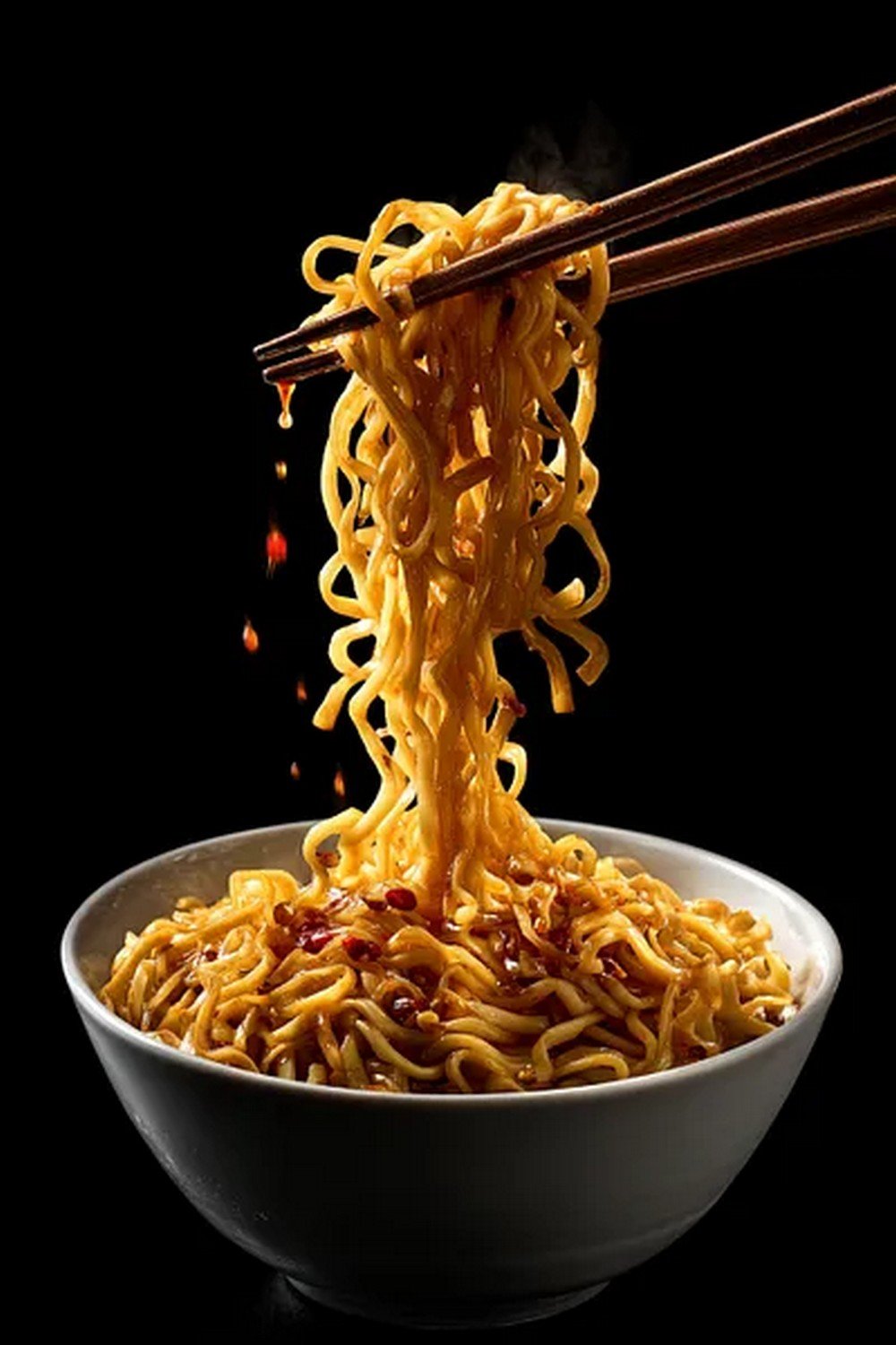 noodles lifted by chopsticks coated in Asian takeout sauce