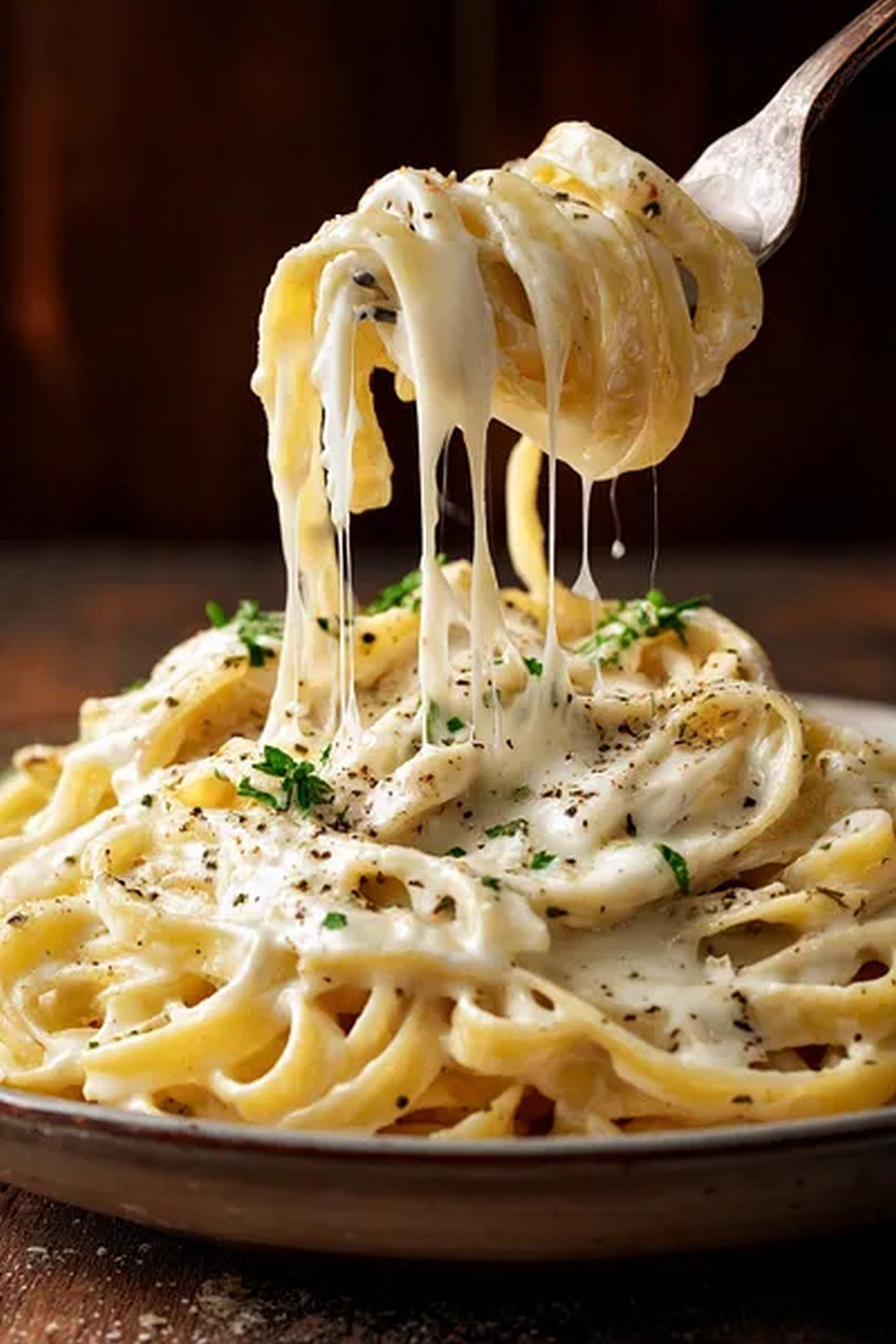 close up texture of thick garlic parmesan cream sauce with visible garlic and cheese
