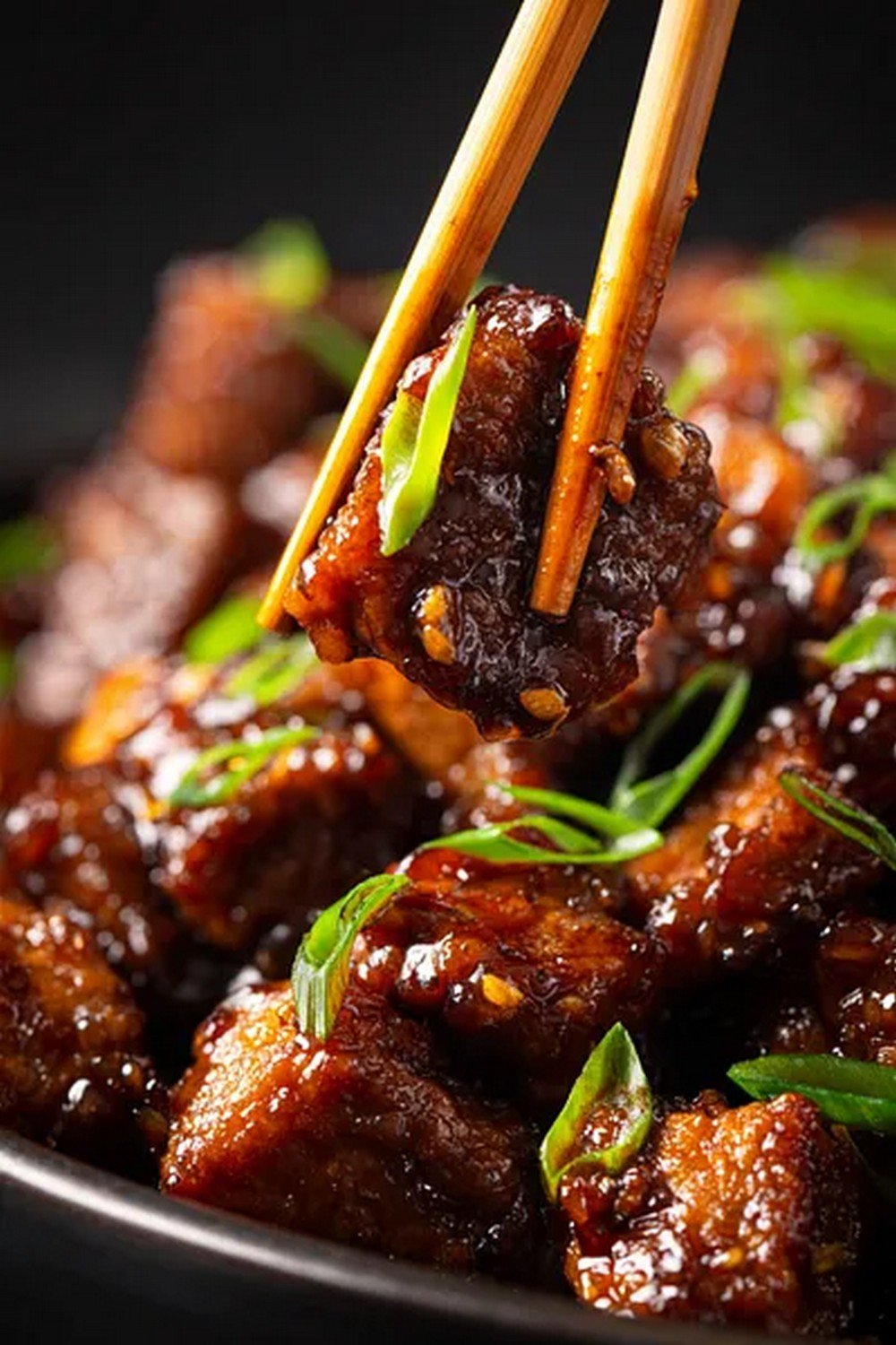chopsticks lifting Mongolian beef with sauce