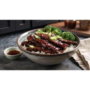 Dark mahogany hoisin glazed beef strips and broccoli over jasmine rice in white bowl on concrete countertop